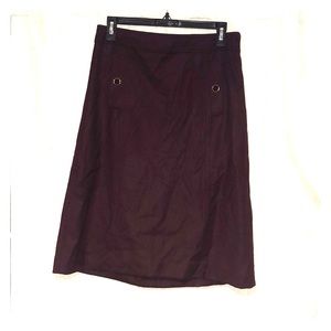 Dark plum work skirt; sits just above the knee.